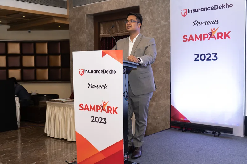 Nikhil Gadkarr speaking at a podium at InsuranceDekho Sampark 2023