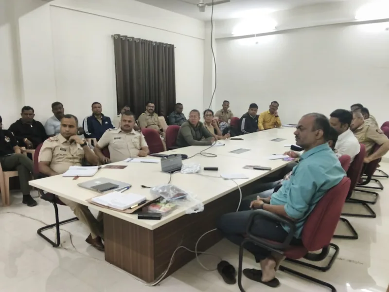 Uniformed police officers seated around a conference table before a session begins
